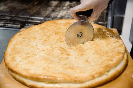 Process of cooking and cutting pizza. Restaurant, cafe or pizzeria cuisineの写真素材