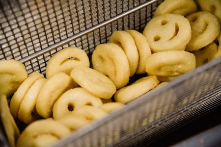 Process of making fried smile of potato on the kitchen. Restaurant or pizzeria cuisine