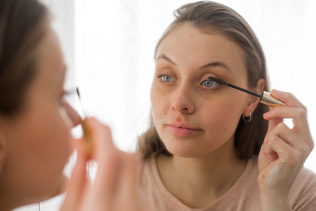 Portrait of attractive young woman putting on makeupの写真素材