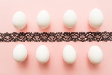 white eggs on pink pastel background. minimal concept. top viewの写真素材