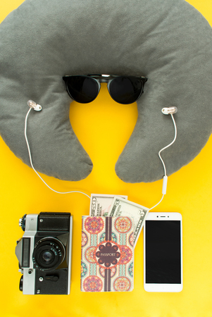Portrait of tipical tourist: all you need in journey, voyage or travel. Passport, sunglasses, neck pillow, headphones, money, camera and smartphone.の写真素材