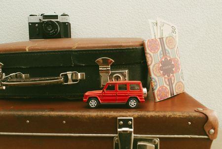 Part of vintage leather travel valises or old suitcase with passport, money, camera and toy car.の写真素材