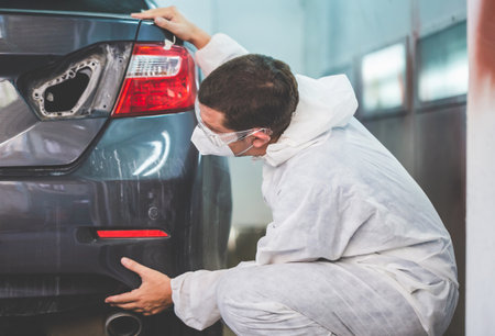 Auto mechanic repairman checking the quality of the painting, The mechanic man painting car in chamber, Garage painting car service repair and maintenanceの写真素材