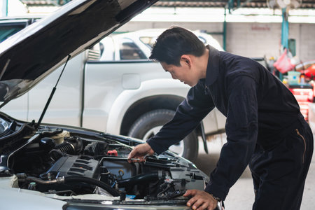 Portrait of a mechanic repairing a car in garage, Auto mechanic working in garage, Maintenance and Repair service.の写真素材