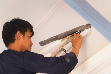 Air conditioning technicians install new air conditioners in homes, Repairman fix air conditioning systems, Male technician service for repair and maintenance of air conditionersの写真素材