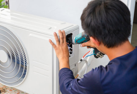 Air conditioning technicians install new air conditioners in homes, Repairman fix air conditioning systems, Male technician service for repair and maintenance of air conditionersの写真素材
