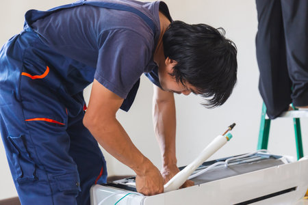 Air conditioning technicians team install new air conditioners in homes, Repairman fix air...