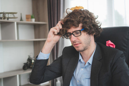 Serious busy business man sitting at office desk, male wearing glasses working at home officeの写真素材
