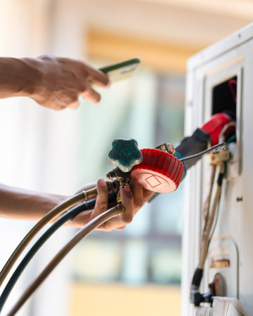 Technician using smartphone memory to check and fix air conditioning system, Repairman service for repair and maintenance of air conditionersの写真素材