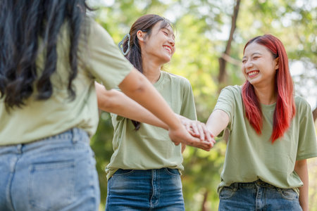 Group of Happy Asian female volunteers team in park for charity event with joining handsの写真素材