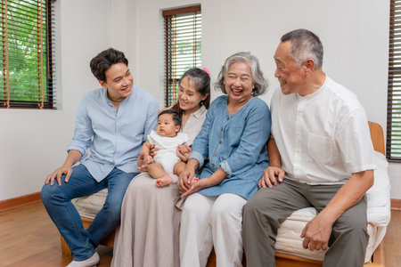 Three Generations of an Asian Family Smiling, Happy Asian Multi-Generational Family Portrait, Joyful Grandparents, Parents, and Baby Togetherの写真素材