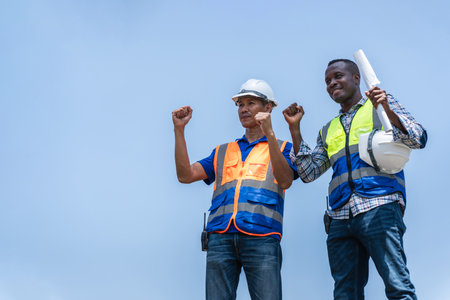Successful Construction Workers Celebrating Achievement, Diverse Engineers in Hard Hats Showing...