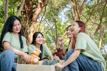 Group of Friends Laughing While Preparing a Donation Box, Young Women Sorting Through Donations for...