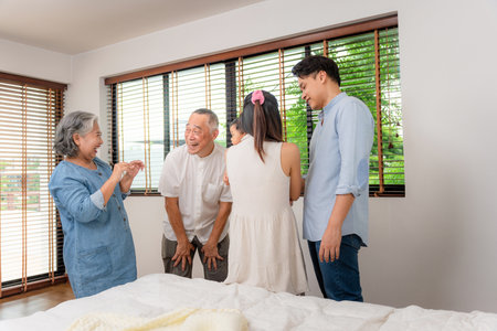 Multi-Generational Asian Family Laughing and Bonding Together in a Bright Home, Grandparents,...