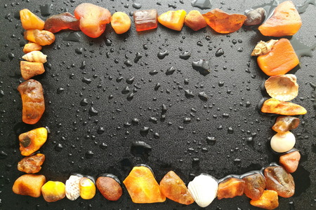 Frame made of natural amber on a dark background with rain drops.の写真素材