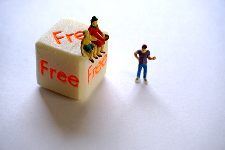 Miniature figures of grandmother and grandson sitting on a cube with the inscription for free, the...