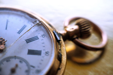 Vintage gold pocket watch with a crack on the glass. The concept of time, past and deadline.の写真素材