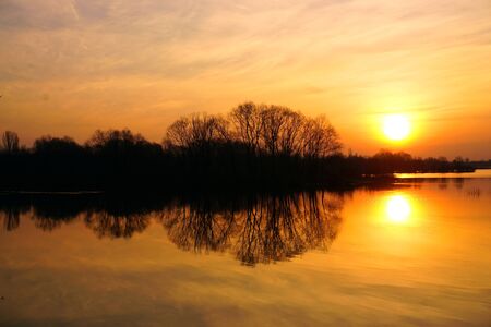 A wonderful Golden sunrise over the river with trees in spring.の写真素材