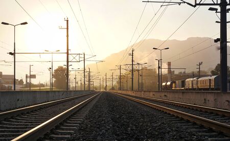 Railway in the morning sunshine and the train with mountain background.