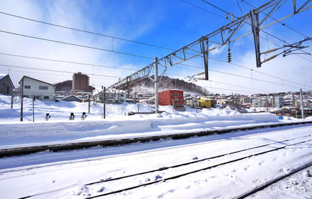 Railway in the snow. Winter landscape with empty rail track and blue skyの写真素材