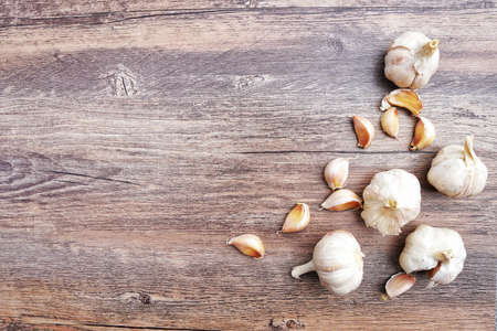 Garlic cloves on wooden desk table vintage background in the kitchen.Top view,Flat lay with copy...