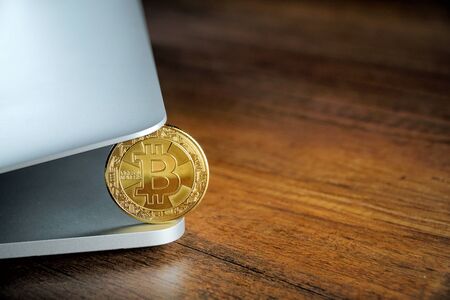 Golden Bitcoins (Cryptocurrency) on laptop.Top view stack of Digital coins on computer keyboard and wooden desk table background.Flat lay blank text.Copy space for word.の写真素材