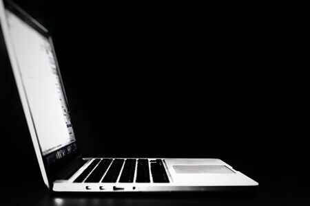 Close up of laptop computer in selective focus on black background in home office.Business...