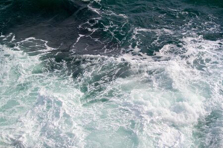 A simple picture of an empty rough sea, with waves crashing, bathed in natural light.