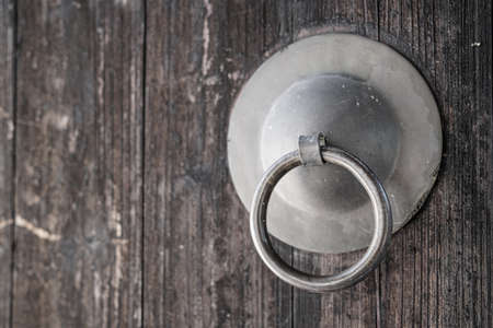 Old metal door handle on a wooden background. Close-up.の写真素材
