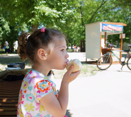  Russia, Eisk,girl 3 years eats ice cream in waffle Cup in the Park                 の写真素材