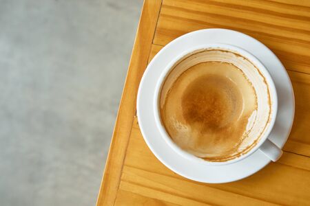 Coffee stain in a coffee cup on wood table,top view angle.