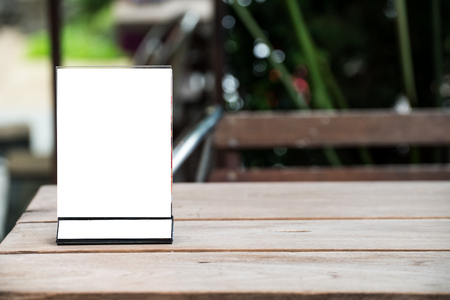 mock up menu object in cafe and restaurant,blank screen for booklet with white sheets of paper on wooden table on cafeteria,copy space for text or graphics objectの写真素材