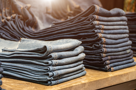 stack of various shades of blue jeans.Denim clothing background.の写真素材