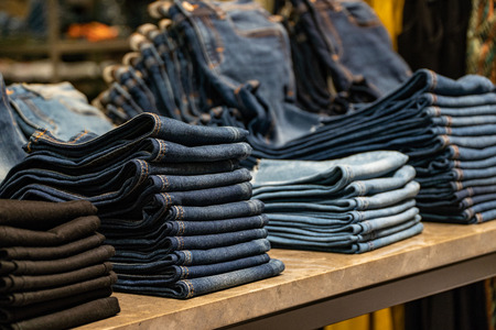stack of various shades of blue jeans.Denim clothing background.の写真素材