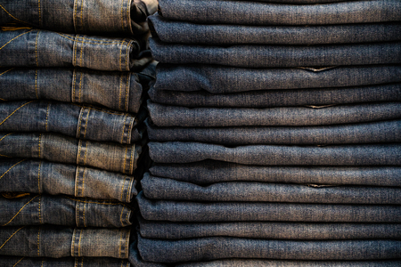 stack of various shades of blue jeans.Denim clothing background.の写真素材