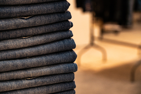 stack of various shades of blue jeans.Denim clothing background.の写真素材