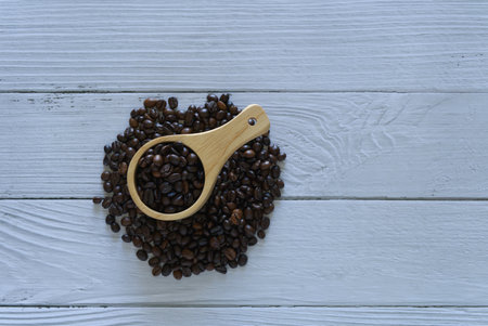 Coffee beans isolated circle with scoop on white wooden backgroundの写真素材
