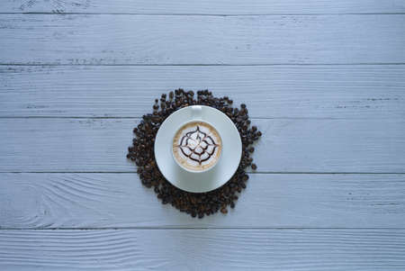 latte art coffee in a coffee cup top view isolated on white wooden background and coffee beans...