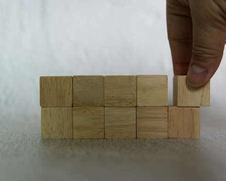 close-up hand choose a rectangle shape wooden dice for Business design concept, activity for child...