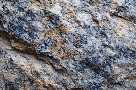 Close up of rough speckled granite stone placed on gray backgroundの素材