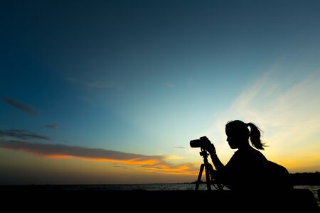 Silhouette of photographer shooting at sunset.の写真素材