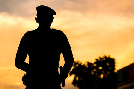 Silhouette rear of police standing on sunset background.の写真素材