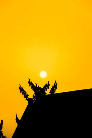 Silhouettes of roof pavilion with sunset. Focus on the sun.の写真素材