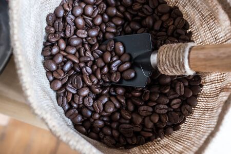 Roasted coffee beans in burlap sack with antique spoonの写真素材