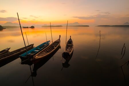 Thai fisherman on local fishing boat at Samchong fishing village on sunrise in Phang-Nga,Thailandの写真素材