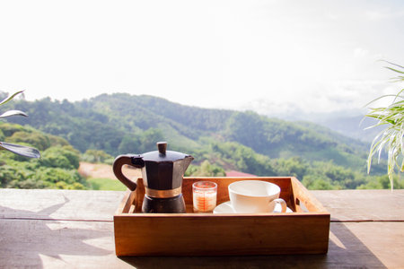 Set of coffee maker,  moka pot on woodle box with mountain and village as backgroundの写真素材
