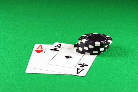 Playing cards showing a pair of aces with poker chips next to them