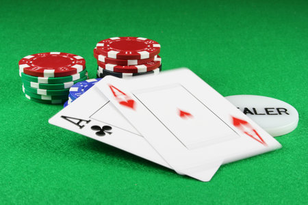 Playing cards showing a pair of aces with poker chips next to them
