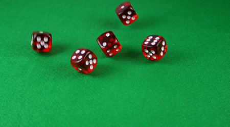 Action shot of 5 dice thrown onto a table - fast shutter showing dice in the air