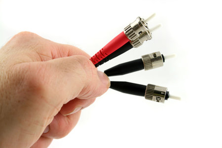 Fiber Optic Computer Cable held in the Hand isolated on a white background